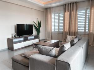 sala de estar con sofá y TV en Airport West 3BR apartment, en Accra