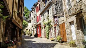 an alley with stone buildings and a red door at Camping de La Hallerais**** in Taden
