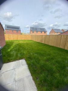 a backyard with a fence and green grass at Guest Village in Hull