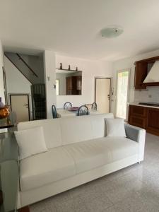 - un canapé blanc dans un salon avec une cuisine dans l'établissement Appena fuori, à Misano Adriatico