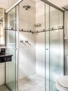 a bathroom with a glass shower with a toilet at Hotel Park Stella Mares in Salvador