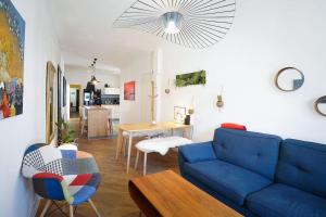 a living room with a blue couch and a table at Le Balcon de la Comédie, Beau T3 Centre Historique in Montpellier