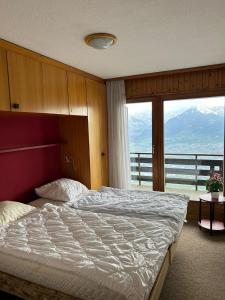 a bedroom with a large bed with a large window at Fontanettaz V 015 - MOUNTAIN apartment 6 pers in Veysonnaz