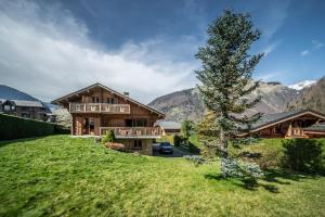 モルジヌにあるChalet L'arba clar - 4 étoilesの庭に木がある山の中の家