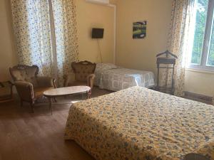 une chambre d'hôtel avec 2 lits, des chaises et une fenêtre dans l'établissement Le Parc aux Cedres, à Laroque