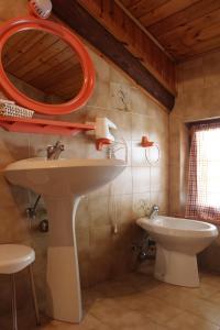 W łazience znajduje się umywalka, lustro i toaleta. w obiekcie Residence Zecchini w mieście Ledro