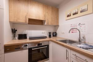 a kitchen with wooden cabinets and a sink at Entspannung in Tirol, Gemütliche Ferienwohnung im Thierseetal, FeWo 14 in Thiersee