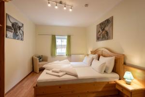 una camera da letto con un grande letto con lenzuola bianche di Familienfreundliche Ferienwohnung mit eigener Terrasse, FeWo 8 a Thiersee