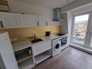 a kitchen with a sink and a washing machine at Impeccable 1-Bed Apartment in London in London