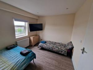 ロンドンにあるImpeccable 1-Bed Apartment in Londonのベッド2台、薄型テレビが備わる客室です。