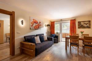 a living room with a blue couch and a table at Familienparadies MoNi Ferienwohnung 4 in Thiersee