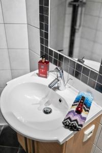 La salle de bains est pourvue d'un lavabo blanc et d'un miroir. dans l'établissement Modern Apartment In The Heart of Bergen, à Bergen