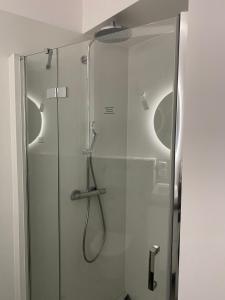 baño con ducha y puerta de cristal en Apartament 33, en Władysławowo