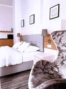 a bedroom with a bed and a chair at Fortune Old Town boutique hotel in Poznań