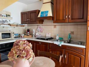 a kitchen with a vase of flowers on a table at Torre Bianca Bisceglie B&B vicino al mare in Bisceglie