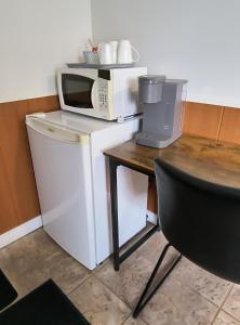 a microwave sitting on top of a refrigerator next to a table at Motel Cabano-Relais in Cabano