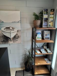 a book shelf with a boat on the beach at Motel Cabano-Relais in Cabano