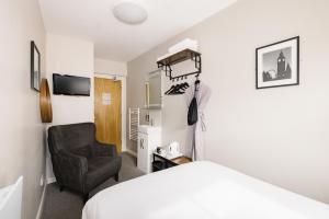 ein Schlafzimmer mit einem Bett und einem Stuhl in der Unterkunft Borough High Street Rooms in London