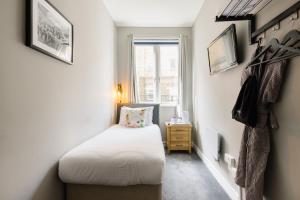 a small bedroom with a bed and a window at Borough High Street Rooms in London