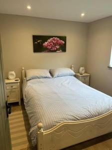 um quarto com uma cama com um quadro na parede em Family friendly rural idyll with space for tents em Wittersham