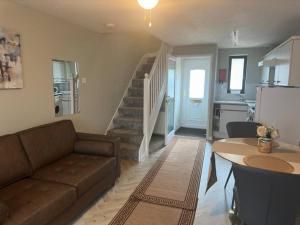 a living room with a couch and a table and a staircase at Caroline's One Bedroom House in Northampton in Northampton