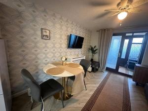 a dining room with a table and chairs and a television at Caroline's One Bedroom House in Northampton in Northampton