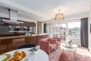 a kitchen and a living room with a table and chairs at Appartement centrum 1 in Ostend