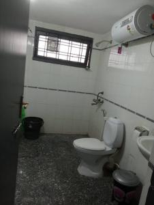 Un baño con inodoro, lavabo y ventana. en Economique Rester @BanjaraHills, en Hyderabad