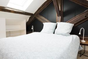 1 dormitorio con cama blanca y techo de madera en EXIGEHOME - Beau duplex-15 min Paris/La Défense/Champs Elysées, en Suresnes