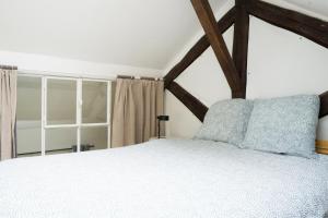 1 dormitorio con cama blanca y ventana en EXIGEHOME - Beau duplex-15 min Paris/La Défense/Champs Elysées, en Suresnes