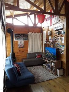 ein Wohnzimmer mit einem Sofa und einem Flachbild-TV in der Unterkunft Romantic Cabin Home ! in Bogotá