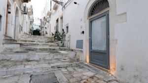 an alley with stairs leading up to a door at Suite al 10 in Ostuni