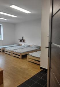 Cette chambre comprend 3 lits et un couloir. dans l'établissement Hostel Warszawa Ursynów, à Varsovie