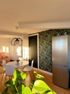 ein Wohnzimmer mit einem Tisch und einem Kühlschrank in der Unterkunft Casa con piscina y jardín con vistas al mar in Puerto de la Madera