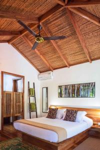 a bedroom with a bed with a ceiling fan at Black Bamboo B&B in Puerto Viejo