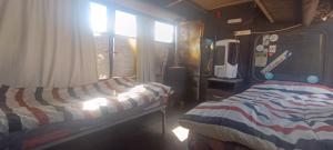 a room with two beds and a window in a bus at BusTel Hostel en Bus in Potrerillos