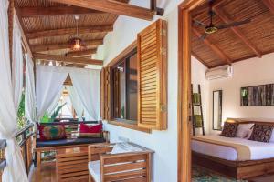 a bedroom with a bed and a window at Black Bamboo in Puerto Viejo