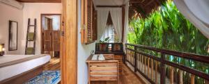1 dormitorio con balcón con cama y ventana en Black Bamboo B&B, en Puerto Viejo