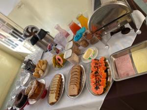 uma mesa com vários tipos diferentes de alimentos em Hotel Central em Araçatuba