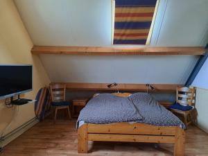 a room with a bed and two chairs and a television at de Boomgaard Groene Hart in Polsbroekerdam