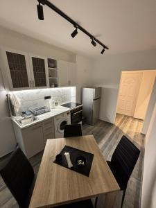 een keuken met een houten tafel en stoelen in een kamer bij Apartman Centar in Kuršumlija