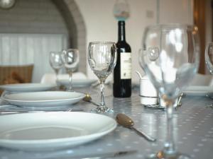 a table with empty glasses and a bottle of wine at Raphael House in Burry Port