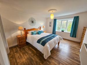 a bedroom with a large bed and a window at Raphael House in Burry Port