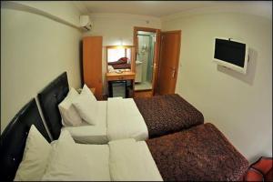 イスタンブールにあるパレス ポイント ホテルのベッドとテレビが備わるホテルルームです。