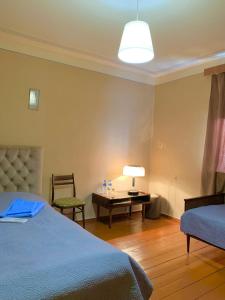 a bedroom with a bed and a desk with a lamp at Villa Bubi in Tbisi