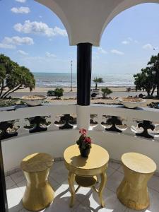 een balkon met een tafel en stoelen en het strand bij Brise de Mer Appartement meublé in Djibouti