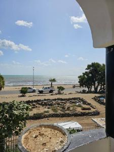 een uitzicht op een strand met auto's geparkeerd op een parkeerplaats bij Brise de Mer Appartement meublé in Djibouti