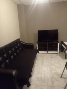 een woonkamer met een bank en een flatscreen-tv bij Apart Trelew 1 in Trelew