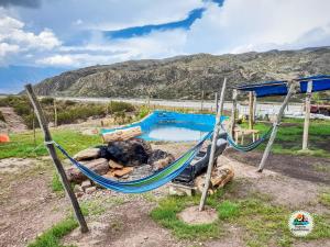 a hammock in front of a swimming pool at BusTel Hostel en Bus in Potrerillos