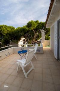 a patio with two chairs and a table on a balcony at 'Alexander' Seaside House With View In Nea Makri in Nea Makri
